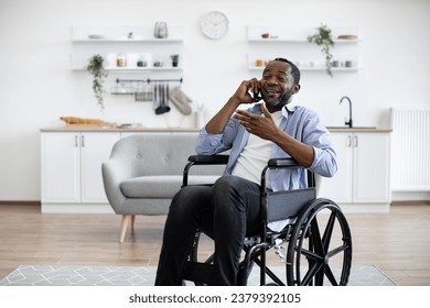 Close up view of african male with mobility impairment being involved in phone talk while relaxing in home interior. Confident person discussing after dinner activity with friends outside apartment. - Powered by Shutterstock