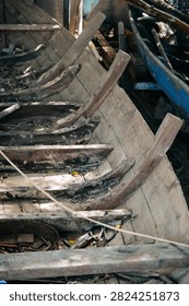 Close view of aged boat framework showing wood grain and worn blue paint