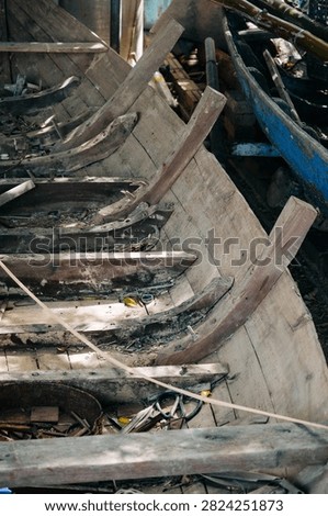 Close view of aged boat framework showing wood grain and worn blue paint