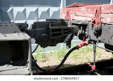 Close view of an aged train coupling, showcasing its intricate details and worn metal.