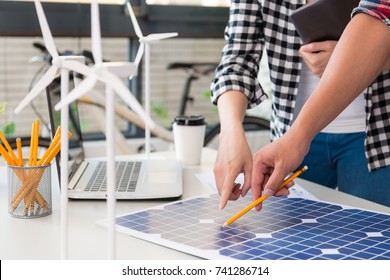 Close Up View Of Alternative Energy Engineer Pointing To A Solar Power Panel And Discussion Team For The Future Power In The Studio