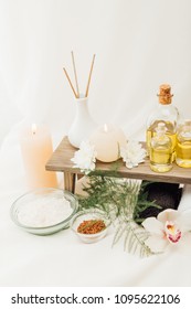 close up view of arrangement of spa treatment accessories with essential oil, salt and candles on white background - Shutterstock ID 1095622106