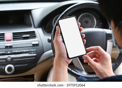 Close up view asian man holding mobile phone while sitting in car. - Shutterstock ID 1975912064