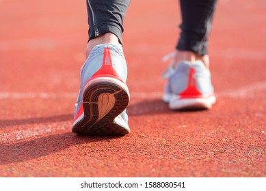close up view of an athlete getting ready for the race on a running track . Focus, on shoe of an athlete about to start a race in stadium .