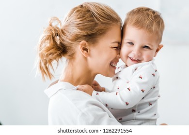 close up view of attractive mother embracing cute toddler son - Powered by Shutterstock