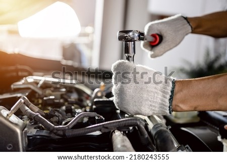 close up of view Auto mechanic repairman using a socket wrench working engine repair in the garage, change spare part, check the mileage of the car, checking and maintenance service concept.