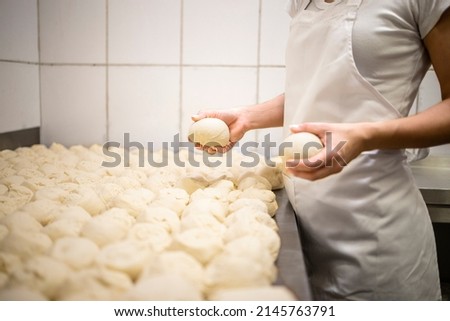 Close up view of baker hands kneading and preparing dough or bred for baking.