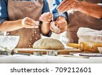 Close up view of bakers are working. Homemade bread. Hands preparing dough on wooden table. 