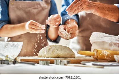 Close up view of bakers are working. Homemade bread. Hands preparing dough on wooden table.  - Shutterstock ID 709212601
