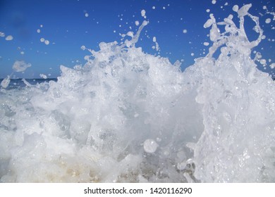 Close up view at beautiful wild ocean wave hitting the shore