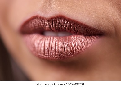 Close Up View Of Beautiful Woman Lips With Metallic Brown Lipstick. Fashion Make Up. Studio Shot