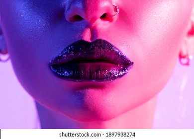 Close up view of beautiful woman lips in colourful bright neon uv lights.