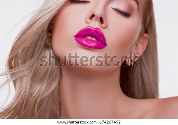ピンクの光る口紅を持つ美しい女性の唇の接写 セクシーな大きな唇 美しい輝くリップメイク しつこいリップグロス 白い歯で口を開く ビューティースタジオショット 激しいキス の写真素材 今すぐ編集