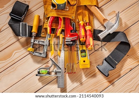 Close Up View Big Set Of Carpenter Tools In Leather Tool Belt On Background Of Wooden Beams