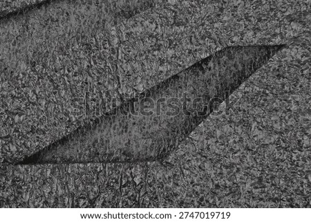 A close up view of black expanded polyethylene foam sheets shows a textured cellular surface with a sharp diagonal layered cut in the material
