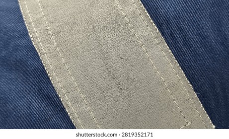 Close Up View of Blank Leather Patch Stitched on Dark Blue Fabric