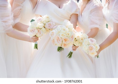 Close up view of bride and four bidesmaids holding beautiful trendy bouquets with fresh roses.