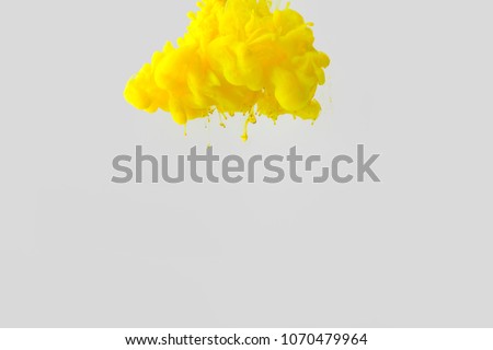 close up view of bright yellow paint splash in water isolated on gray