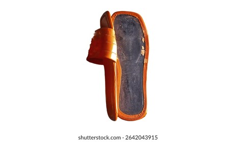 Close up view of the broken sole of an orange sandal, isolated on a white background.