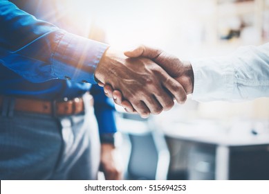 Close up view of business partnership handshake.Concept two businessman handshaking process.Successful deal after great meeting.Horizontal,flare effect, blurred background