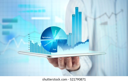 Close view of businessman with tablet and graphs and charts on screen - Shutterstock ID 521790871