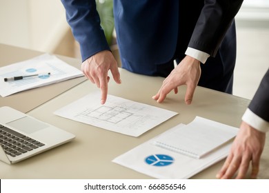 Close up view of businessmen discussing building plan, property value estimation, analyzing real estate market with infographic statistics, house evaluation, construction investment, home appraisal  - Powered by Shutterstock