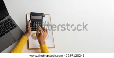 Close up view of businesswoman using calculator to estimate the budget for company.