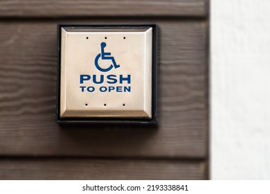 Close up view of button to open wheelchair accessible door of building. The button for disability access allows people with a disability to enter a building independently which promotes inclusion. - Shutterstock ID 2193338841