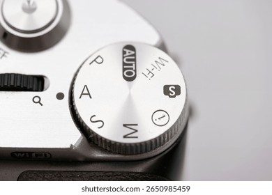 Close up view of a camera settings dial displaying modes such as auto, manual, and wireless. This shot captures the attention of photography professionals in a studio atmosphere.