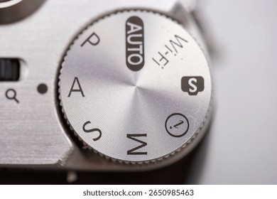 Close up view of a camera settings dial featuring multiple modes like manual and auto transmission. The focus is on the details, highlighting the precision in photography.