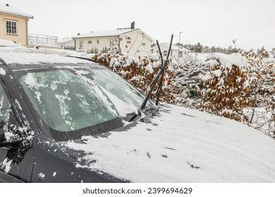 Close up view of a car in ice and snow, with raised windshield wipers on a cold winter day. Sweden. - Powered by Shutterstock