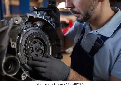 Close up view of car mechanic repairing gearbox in auto workshop, copy space