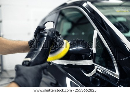 Close up view of car polishing process. Expert polish vehicle rear view mirror.