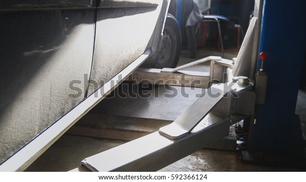 Close up view of car service station - auto\
standing in garage, sunny\
midday