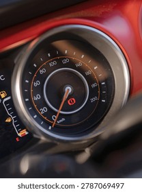 Close up view of a car speedometer and dashboard gauge showing speed and RPM.