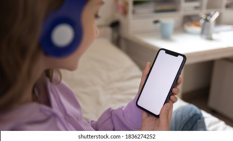 Close up view of Caucasian teenage girl look at white mockup smartphone screen chat text on gadget. Smart teenager use cellphone device, talk speak on video call online, browse wireless internet. - Powered by Shutterstock