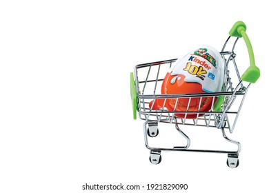 Close up view of children's favorite chocolate Kinder surprise in toy shopping cart on white background. Uppsala. Sweden. 02.22.2021.