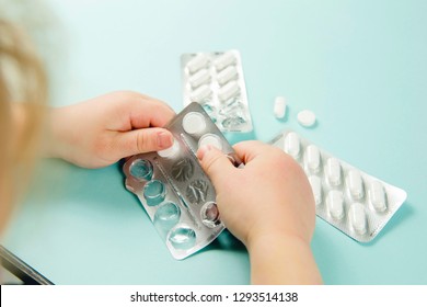 Close Up View Of Child`s Hands With Blister Pack, Young Child Play Alone With Pills Tablets At Home.  Keep Away From Children Reach Concept. No Medicine Cabinet, Raise Awareness.