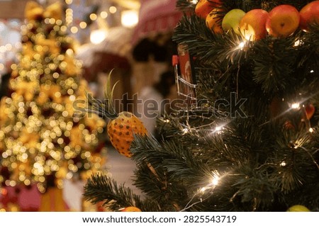 close view of a christmas tree decorated with citrus,apple and pineapple ornaments and warm fairy lights, creative seasonal decor idea, cozy festive atmosphere with soft bokeh