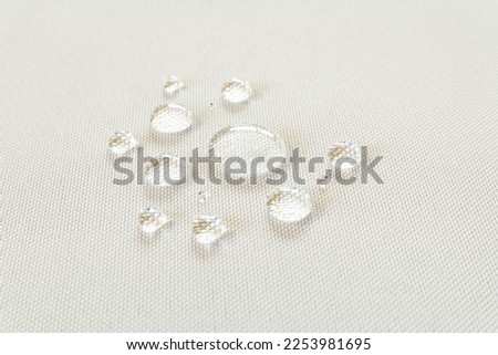 Close up view of the clear water drops on the white waterproof tablecloth fabric