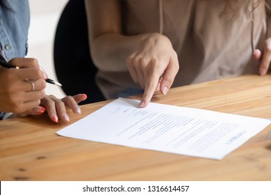 Close Up View Of Client Customer Hand Put Signature On Business Contract, Female Lawyer Solicitor Pointing At Paper Showing Where To Sign Document Selling Services Making Financial Legal Deal Concept