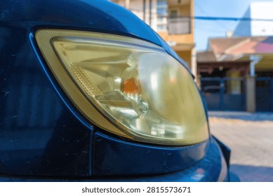 Close up view of a cloudy and yellowed old car headlight lens. Automotive part template for vehicle headlight restoration, cleaning service, or car detailing concept.