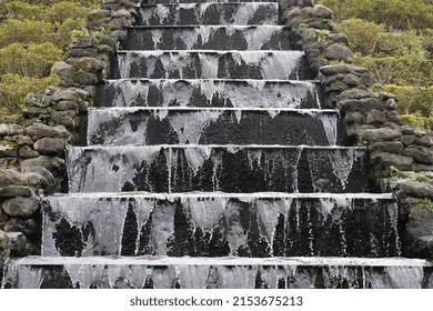 Close Up View Of Concrete Stairs With Cascade Of Water On Decorative Waterfall. Concept Of Landscaping Design In Public Parkland On Private Garden