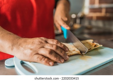 Close Up View Of A Cook Cutting A Taco In Half In A Kitchen