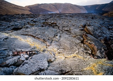 Close up view of cracked lava crust or ingenious rock and steam, cooled down from 2021 eruption of volcano Mt. Fagradalsfjall in Geldingadalir valley on Reykjanes Peninsula near Grindavik, Iceland