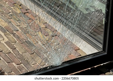 Close Up View Of Cracks In A Pane Of Toughened Glass In A Door After Being Struck By An Object. No People.