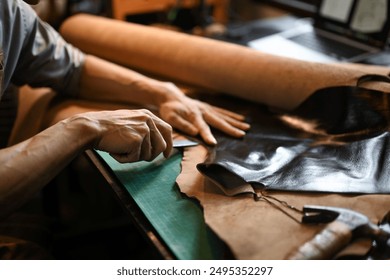 Close up view of craftsman skillfully using a cutting tool to shape the leather. - Powered by Shutterstock