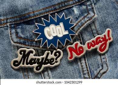 Close Up View Of Denim Jacket With Cool Graphic Pins, Funky Hippie Metallic Fashion Accessories, Cool Garment Brooches