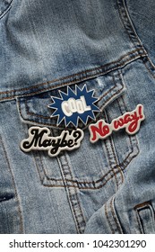 Close Up View Of Denim Jeans Jacket With Cool Graphic Pins, Funky Metallic Brooch, Fashion Accessories