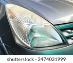 Close up view of dirty car headlight with hazy and unpolished glass